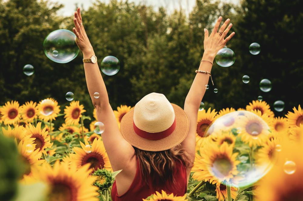 femme-heureuse-dans-un-champ-de-tournesol